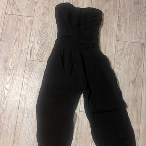 Body central strapless romper with tapered legs zipper on side and pockets.